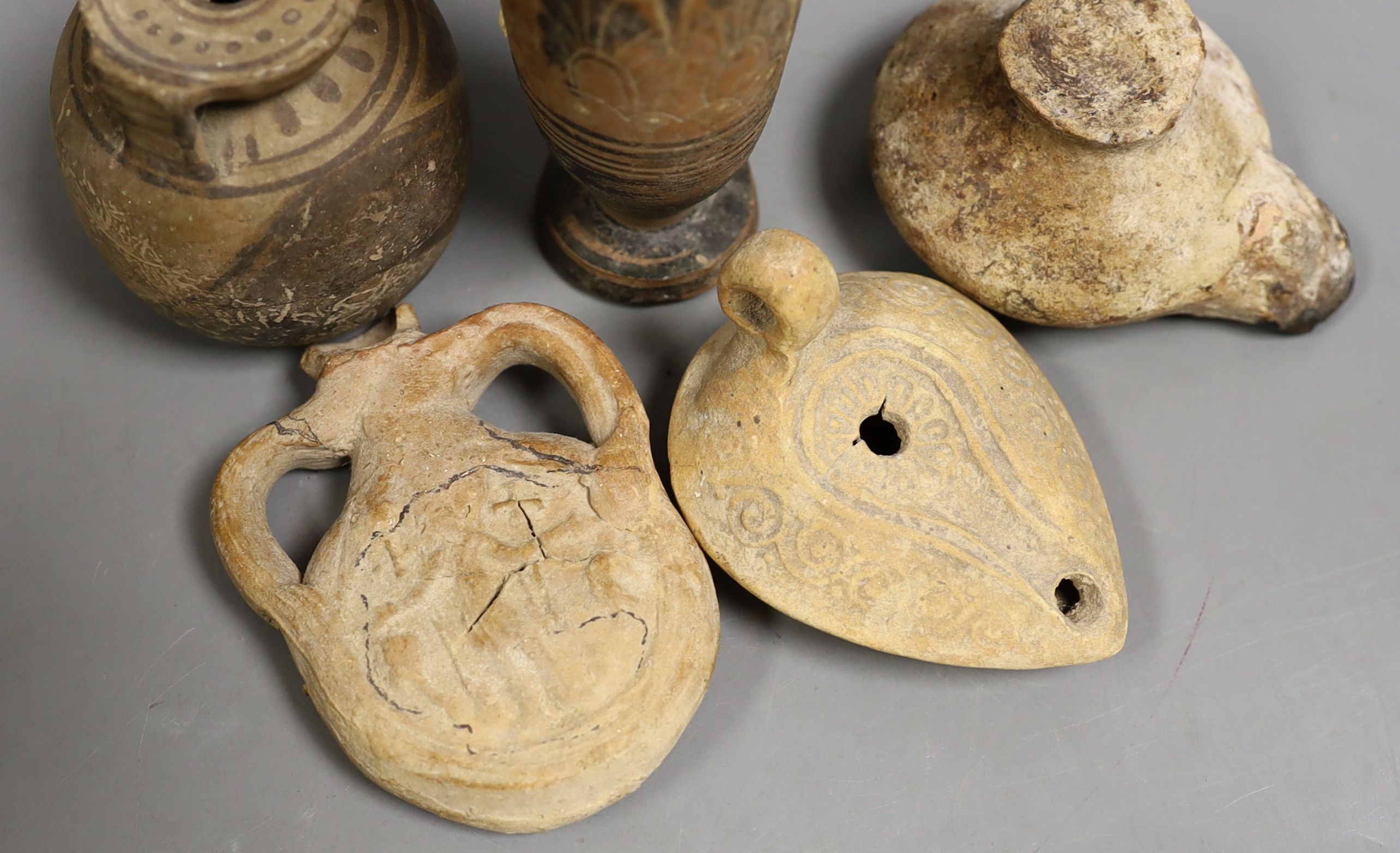 Two Ancient Greek painted pottery vessels, Apulia 3rd-4th century BC, two Roman/Byzantine oil lamps and a pilgrim flask, Tallest 15 cms high (5)